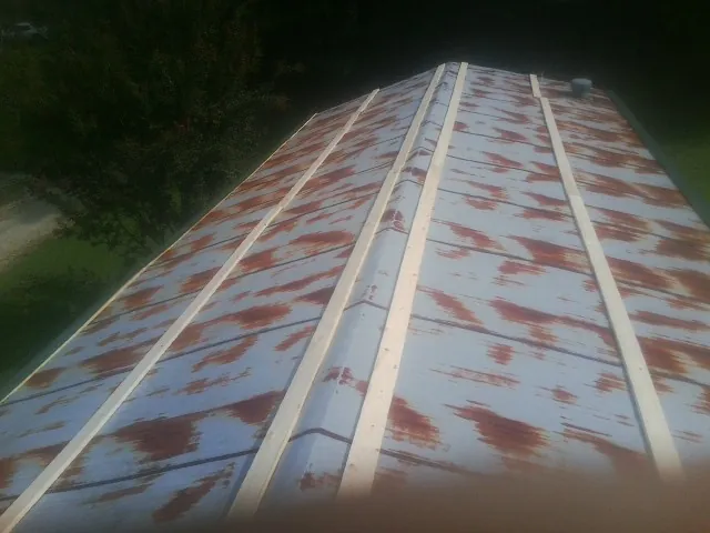 Rusted metal roof panels with new wood purlins before replacement — Storm Damage Roof Repair in Aulander by Roofing Brothers