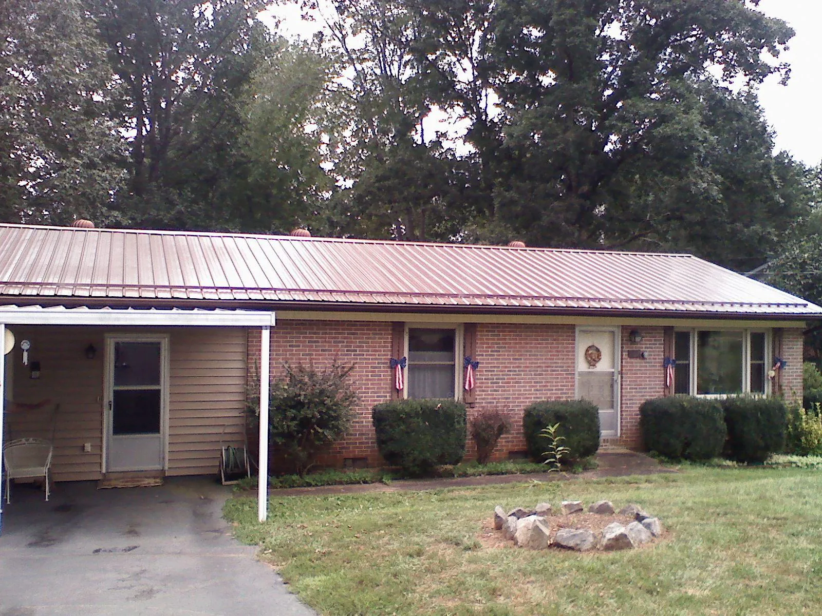 Bronze metal roof and carport on a brick ranch home — Roof Repair work by our crew in Aulander
